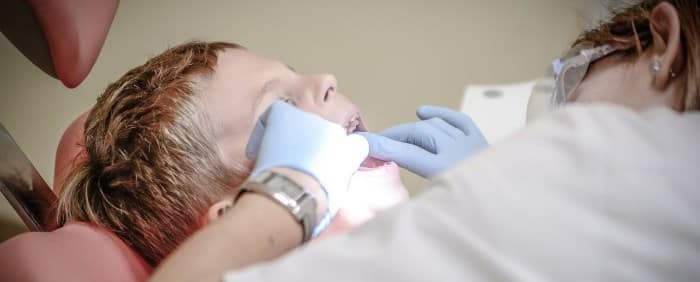Dentist checking up the teeth of a boy