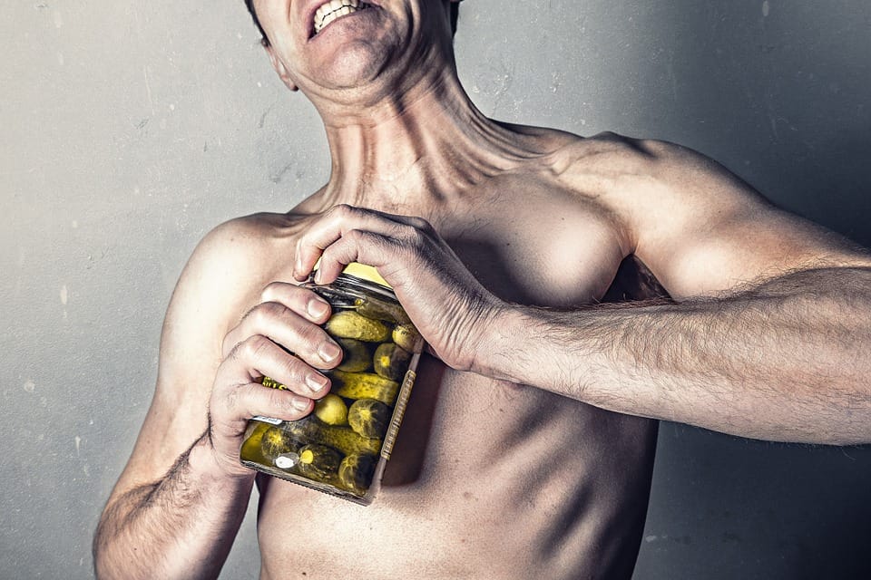 Man opening the lid of a jar